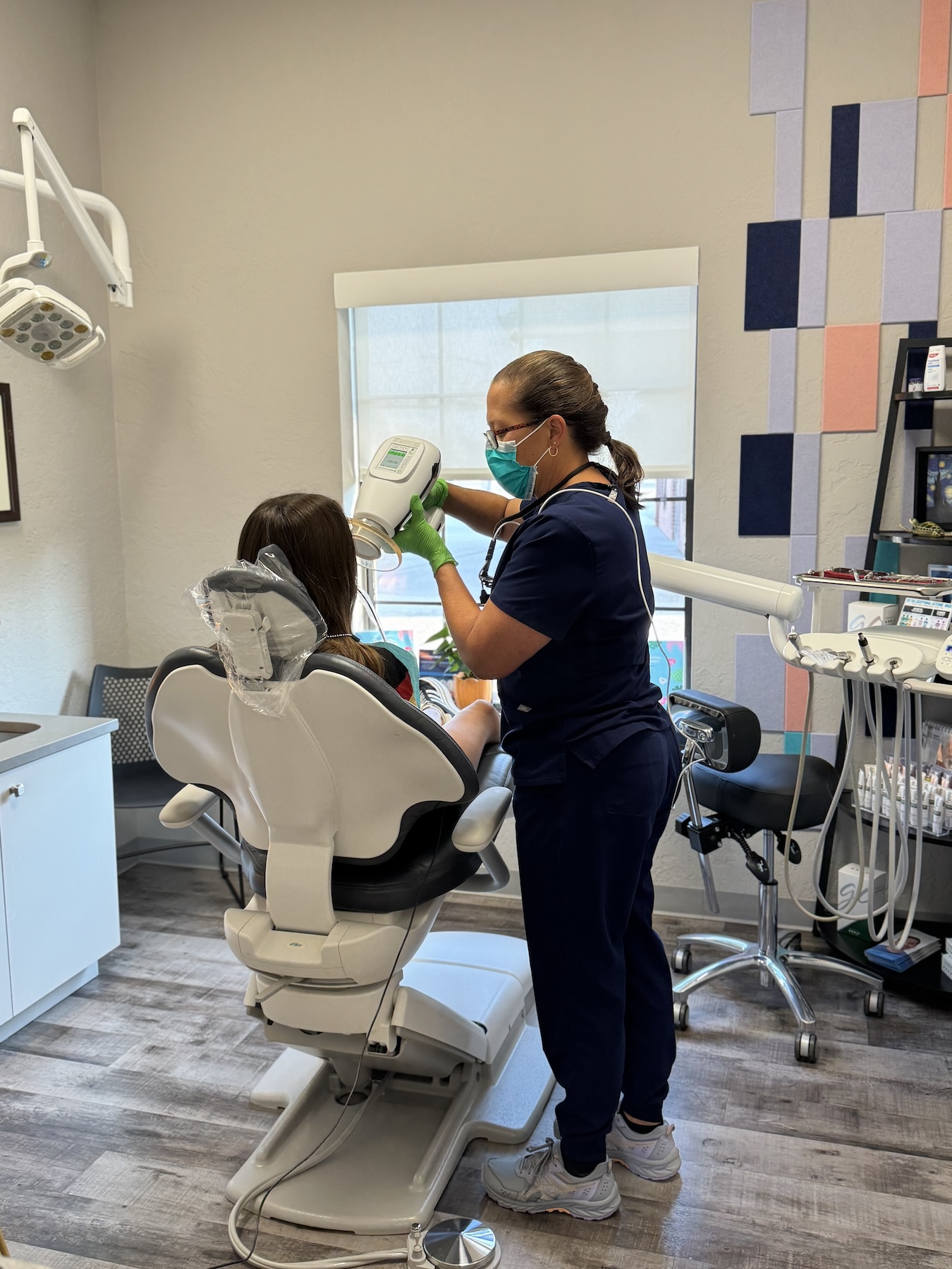 A dental office with a dentist and patient in a chair, preparing for a dental procedure.