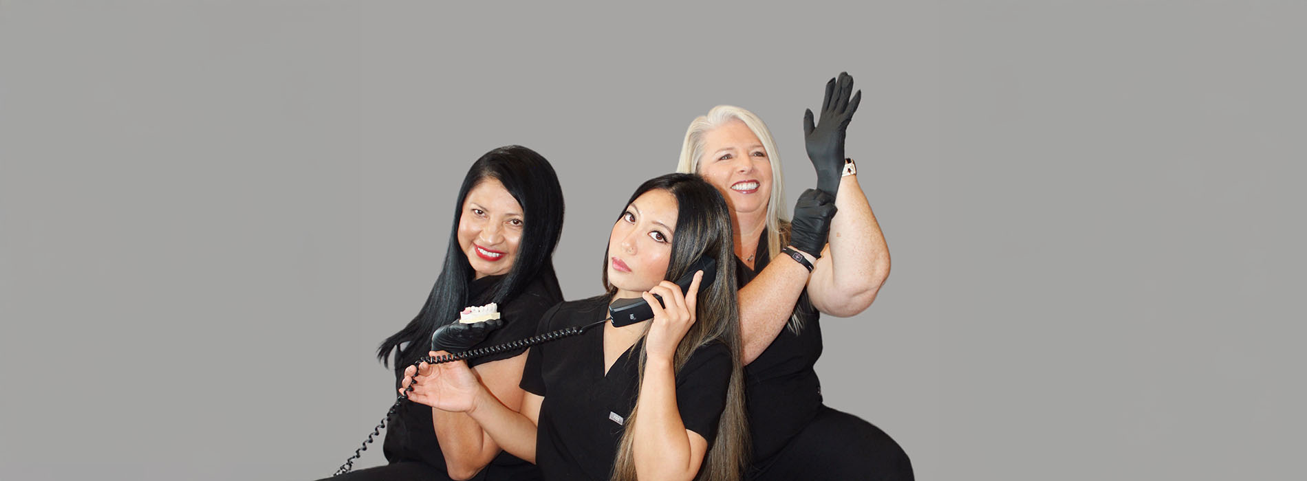 The image features three women standing together with microphones, smiling and posing for the camera.